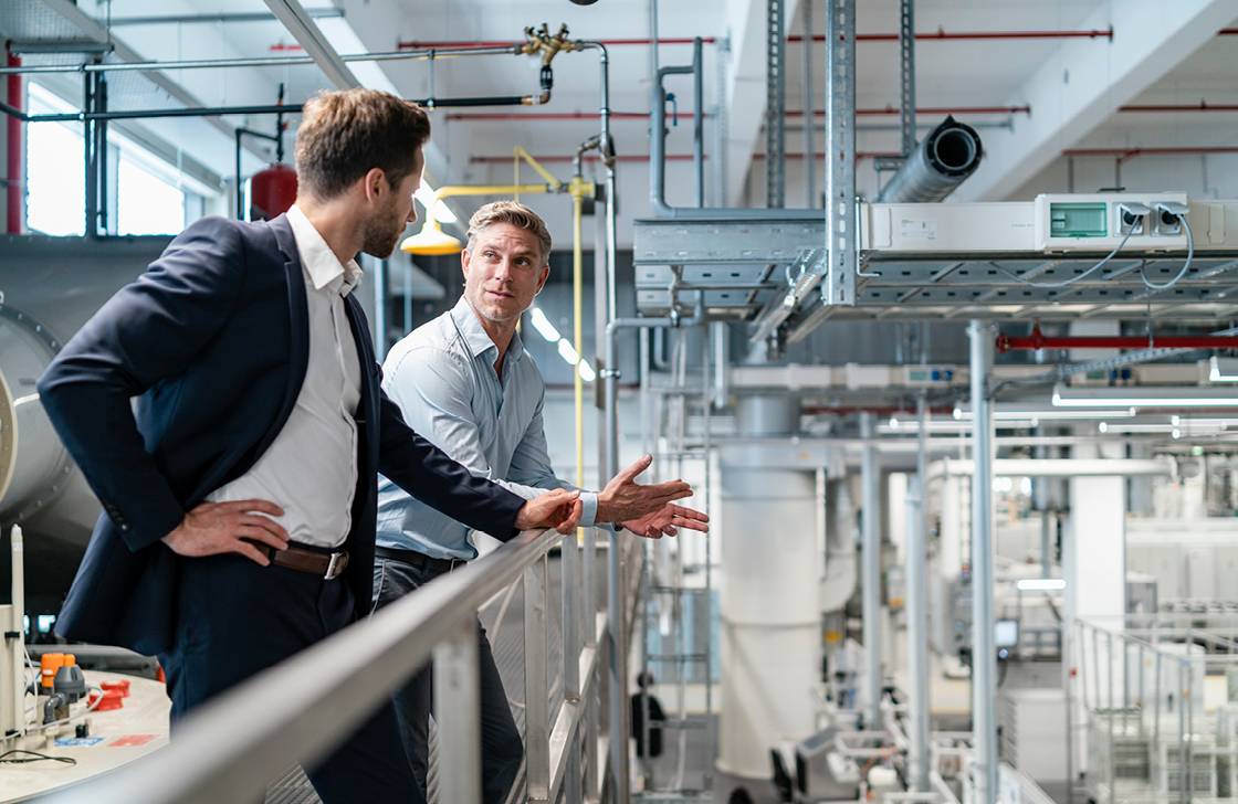 Two men talking in a factory