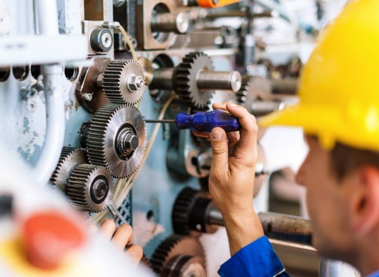 Close up of a man screwing into a gear