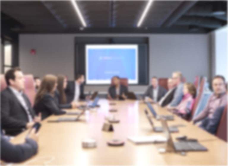 Soft focus image of the Novo Advisors Leadership team meeting at a conferance table in their board room
