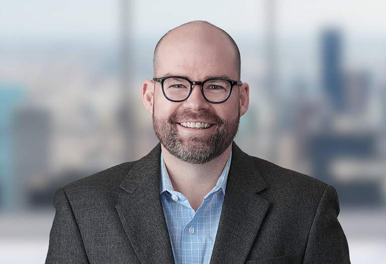 Picture of Brent Nicholson in front of a blurred office image
