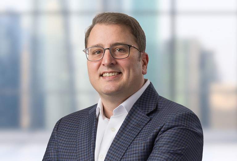 Picture of Rian Branning in front of a blurred office image