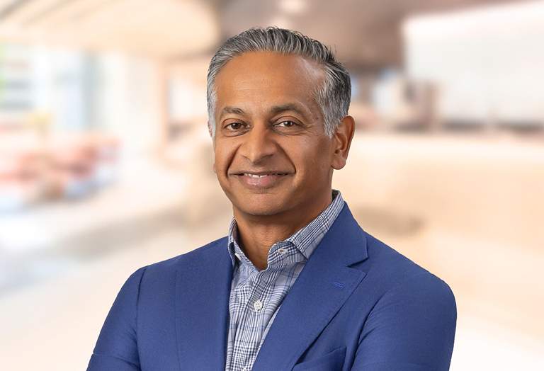 Picture of Sandeep Gupta with a blurred office background