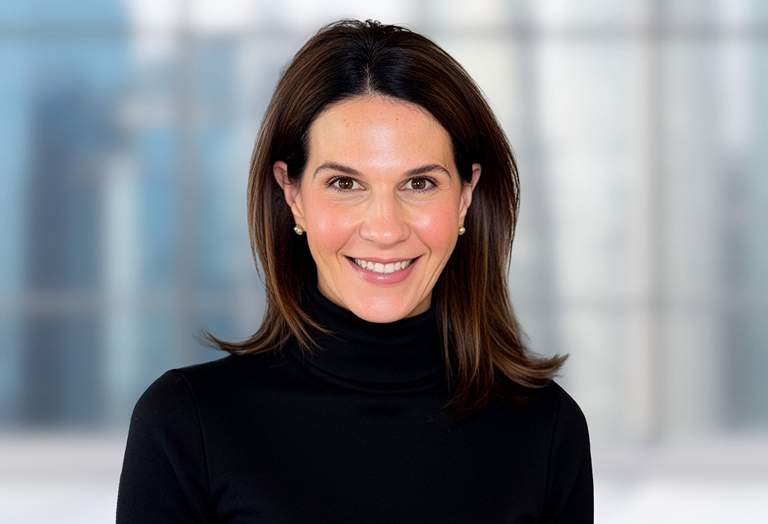 Nicole Brownell, Managing Director in front of a soft focus architectural background